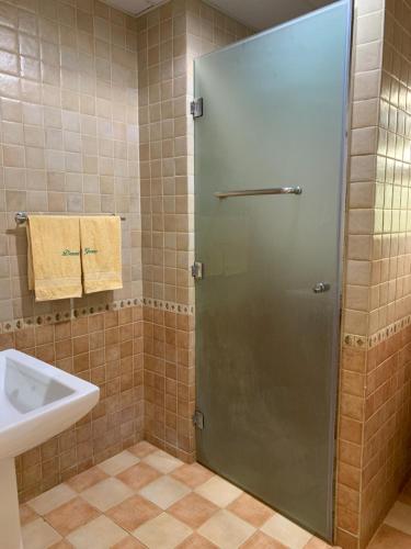 a shower with a glass door in a bathroom at Arabian Nights Nook in Muscat