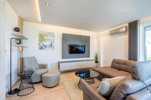 ein Wohnzimmer mit einem Sofa und 2 Stühlen in der Unterkunft MF Sunset Beach77 Premium Apartment in Siófok