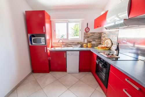 フュリアニにあるSuperbe T3 en villa , entree sud de bastia ( Furiani )のキッチン(赤いキャビネット、シンク付)