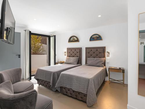 a bedroom with a bed and a chair at Villa cala Vinyas in Cala Vinyes