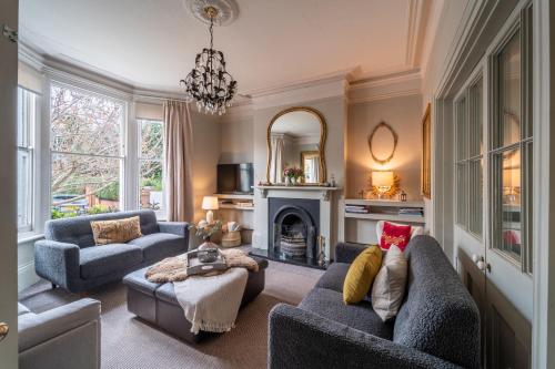 a living room with two couches and a fireplace at Victorian Townhouse 5 bedrooms Cheltenham in Cheltenham
