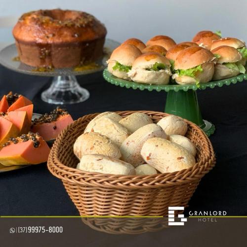 a basket of buns on a table with a cake at Gran Lord Hotel in Pará de Minas