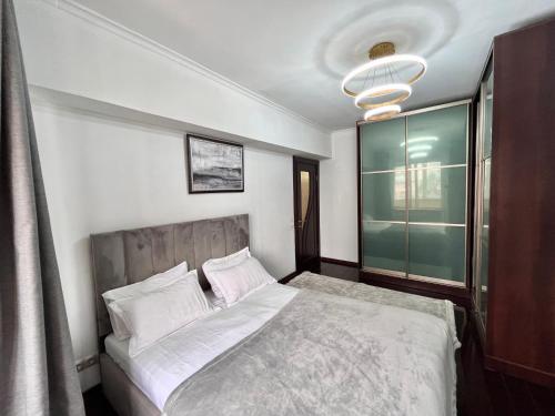 ein Schlafzimmer mit einem Bett und einem Fenster in der Unterkunft Great location Arbat, Zhibek zholy 81 & drinking water in Almaty
