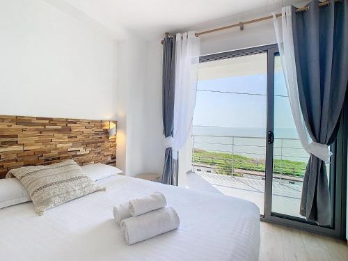 une chambre avec un lit blanc et une grande fenêtre dans l'établissement Villa Heure Bleue, à Saint-Georges-de-Didonne