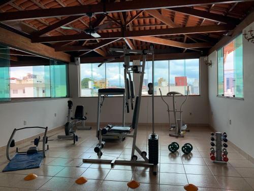 un gimnasio con varios equipos de ejercicio en una sala con ventanas en Gran Lord Hotel en Pará de Minas