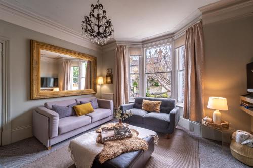 Sala de estar con 2 sofás y espejo en Victorian Townhouse 5 bedrooms Cheltenham, en Cheltenham