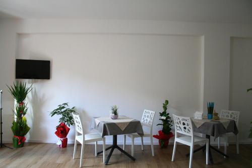 Un comedor con dos mesas y sillas blancas. en Annabella Bed and Breakfast, en Giffoni Valle Piana