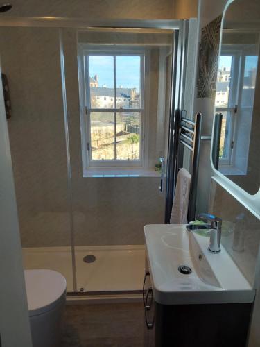 a bathroom with a shower and a sink and a toilet at East Claremont Guest House in Edinburgh