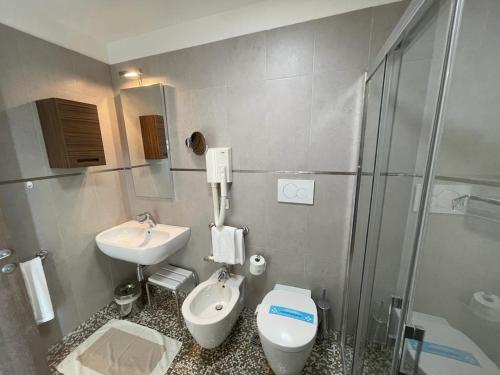 a bathroom with a sink and a toilet and a shower at Hotel Italy in Bibione