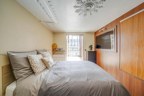 - une chambre avec un lit et une télévision au plafond dans l'établissement Appartement Grands Boulevards, à Paris