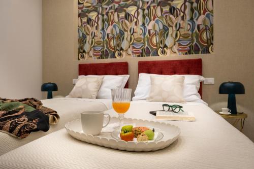 a tray with a plate of food on a bed at Ducrot Apartment in Palermo