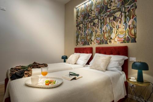 a hotel room with two beds with a plate of food at Ducrot Apartment in Palermo