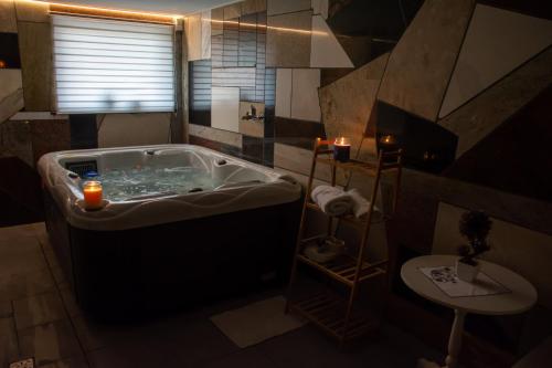 a bathroom with a large tub with candles in it at Checz Gościnna- pokoje,sauna,jacuzzi, sala konferencyjna in Grzybno