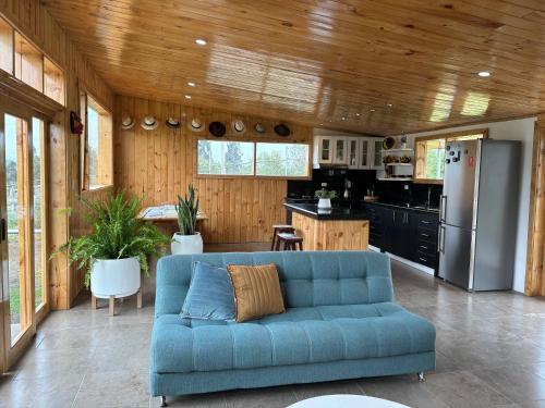 sala de estar con sofá azul en la cocina en Country home with grill, en Latacunga