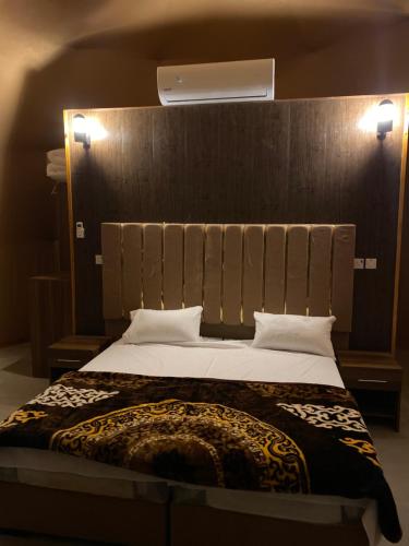 a bedroom with a large bed with a wooden headboard at Desert Star Luxury Camp in Wadi Rum