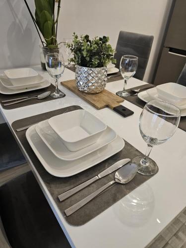 a dining table with white plates and silverware on it at 2 Bed Apartment in Zyrardow in Żyrardów