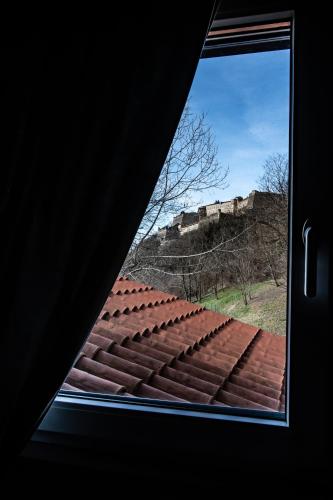 a window view of a roof with a castle in the background at Monte Moro Gavi B&B in Gavi