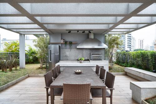 patio con mesa y sillas y cocina en Apartamentos completos em Pinheiros a uma quadra da Faria Lima - HomeLike, en São Paulo