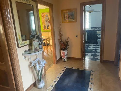 a hallway with a vase of flowers on a tile floor at Casa Begoña - 7803 in Castillo