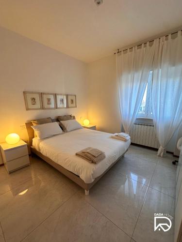 a bedroom with a bed with two lamps and a window at DADA Home in Bari