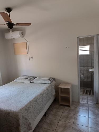 a bedroom with a bed and a ceiling fan at Casa no centro de Penha in Penha