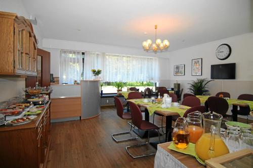 cocina y comedor con mesas y sillas en Hotel Rennekamp, en Oyten