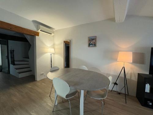 une salle à manger avec une table et des chaises blanches dans l'établissement L'ARLAPPART Centre-ville Arles, à Arles