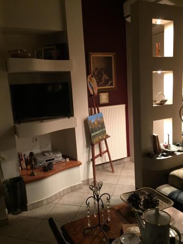 sala de estar con TV de pantalla plana en la pared en The A project, Gallery Suites en Agria