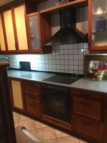 a kitchen with wooden cabinets and a stove top oven at The A project, Gallery Suites in Agria