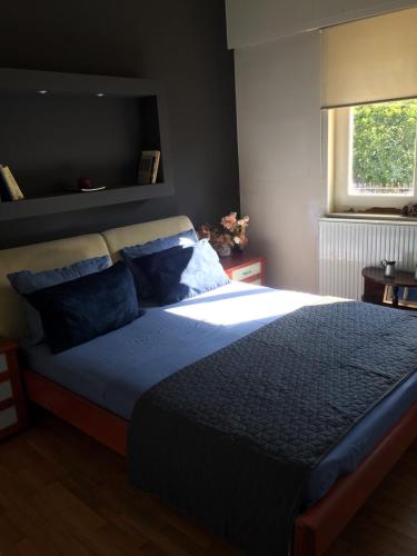 1 dormitorio con 1 cama grande con almohadas azules en The A project, Gallery Suites en Agria