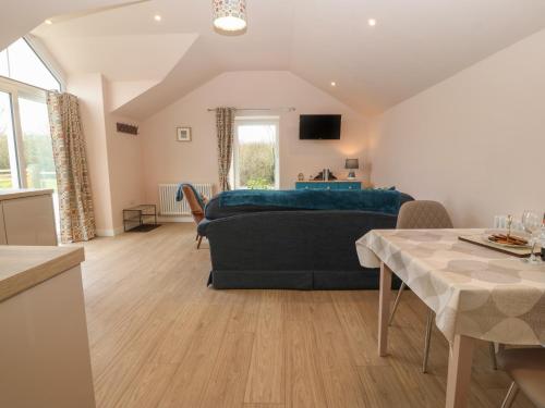 a living room with a blue bed and a table at Y Felin in Caernarfon