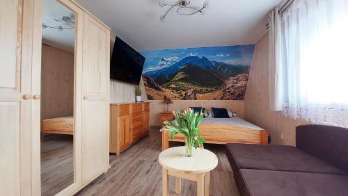 Cette chambre comprend un lit, un canapé et une table. dans l'établissement APARTAMENTY "U Bliźniaków", à Zakopane