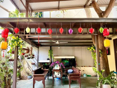 een patio met kleurrijke lantaarns en een tafel en stoelen bij Lee Homestay in Hanoi