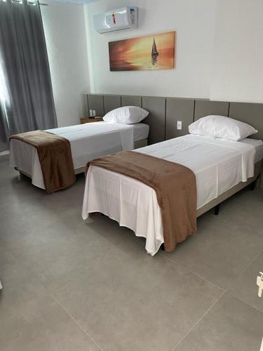 two beds sitting next to each other in a room at Amaliê Pousada in Barra de São Miguel