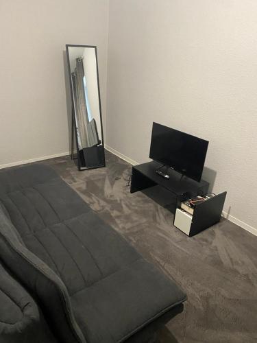 a bedroom with a bed and a flat screen tv at Cozy 2 Rooms Apartment in Bochum