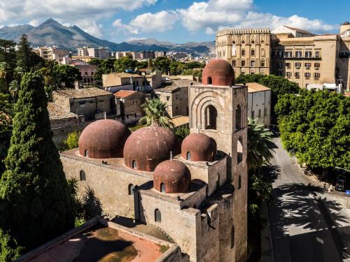 an old building with domes in a city at Ducrot Apartment in Palermo