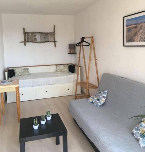 un salon avec un canapé et un lit dans l'établissement Location 1 à 4 pers. dans résidence Front de mer, à Soulac-sur-Mer