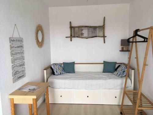 ein Schlafzimmer mit einem Bett mit einer Leiter und einem Tisch in der Unterkunft Location 1 à 4 pers. dans résidence Front de mer in Soulac-sur-Mer