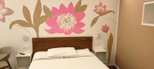 a bedroom with a bed with a flower mural on the wall at Casa Pitem in Nago-Torbole
