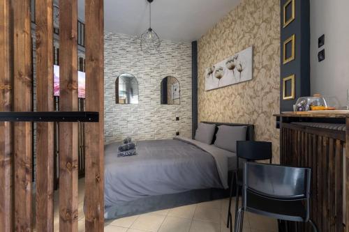 - une chambre avec un lit et un mur en briques dans l'établissement GpxClr GuestSuiteNo2, à Larissa