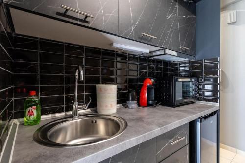 - un comptoir de cuisine avec évier et four micro-ondes dans l'établissement GpxClr GuestSuiteNo2, à Larissa