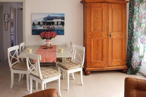 a dining room with a table and chairs with a vase of flowers at The Pink House in Halmstad