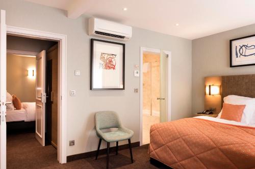 a hotel room with a bed and a chair at Aragon House in Bruges