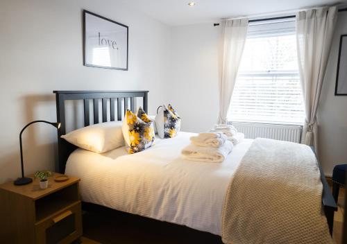 a bedroom with a bed with white sheets and a window at Hope Apartments Belfast - South in Belfast
