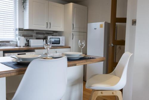 ベルファストにあるHope Apartments Belfast - Southのキッチン(テーブル、椅子、白い冷蔵庫付)