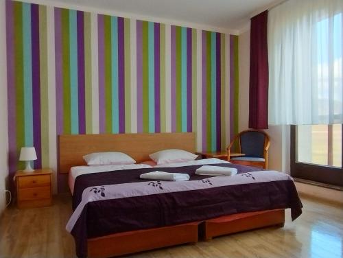 a bedroom with two beds and a striped wall at Ośrodek Wypoczynkowy Zapalenica in Szczyrk