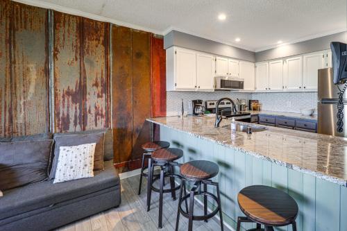 a kitchen with a couch and a bar with stools at 2 Mi to Skiing! Beech Mtn Condo with Resort Perks in Beech Mountain