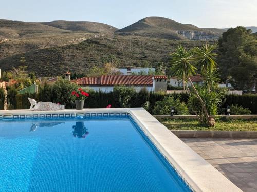 a swimming pool with mountains in the background at Buen Estar, piscina, barbacoa, jacuzzi en Valencia in Turís