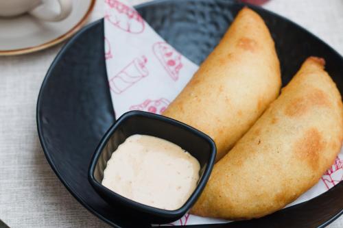a plate of food with a bowl of dipping sauce at Valle de Santiago Hotel Boutique in San Cristóbal