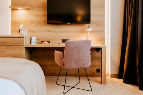 a bedroom with a desk with a chair and a television at FischerS in Kassel